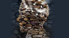 Darstellung eines Kopfes aus Steinen. Durch die Spalten stahlt ein Licht.