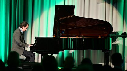 Pianist Manuel Krass am schwarzen Flügel auf der Bühne des Festsaals.
