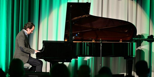 Pianist Manuel Krass am schwarzen Flügel auf der Bühne des Festsaals.