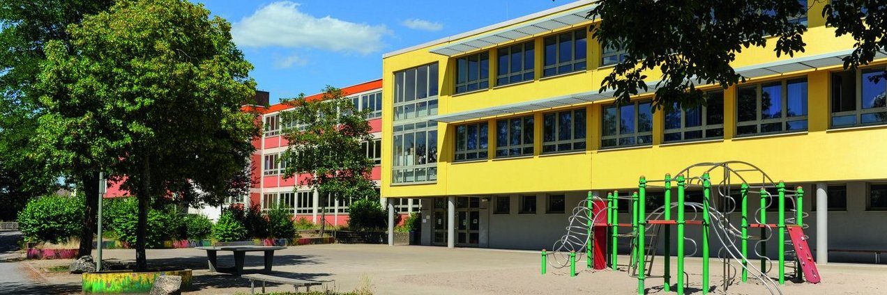 gelbes Schulgebäude mit Schulhof der Gemeinschafsschule Kleinblittersdorf