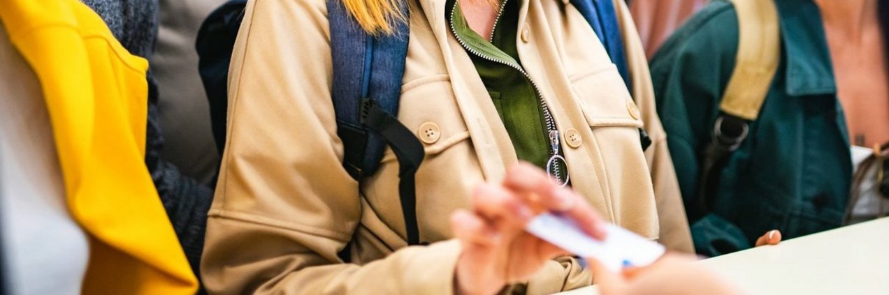 Mehrere Menschen erhalten am Tresen eine Karte