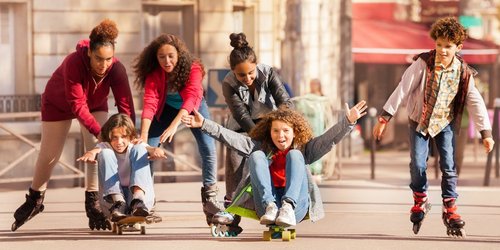 Kinder mit Inlineskates fahren durch die Stadt