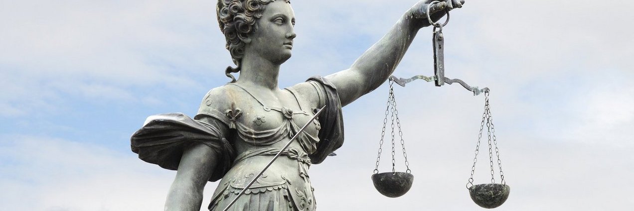 Justitia, Göttin der Gerechtigkeit mit Waage in der linken und Richtschwert in der rechten Hand. 
