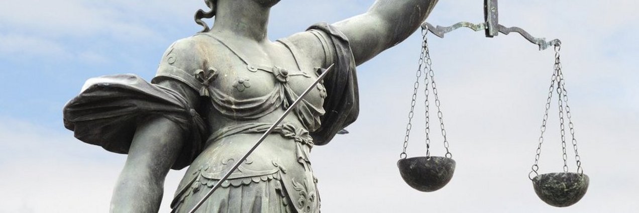 Justitia, Göttin der Gerechtigkeit mit Waage in der linken und Richtschwert in der rechten Hand. 