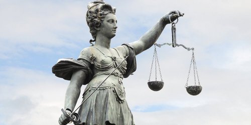 Justitia, Göttin der Gerechtigkeit mit Waage in der linken und Richtschwert in der rechten Hand. 