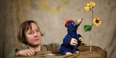 Maren Kaun sitzt hinter der Figur eines Maulwurfs, neben ihm eine Sonnenblume.