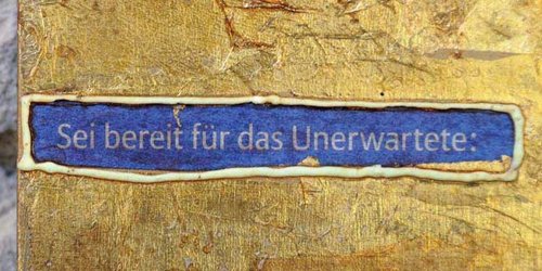 Wand mit Goldenem Element und blauem schild mit Schriftzug