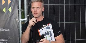 Konstantin Rohr vor einem Bauzaun stehend.
