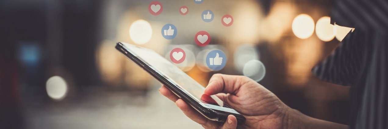 Social Media Smartphone Smartphone in einer Hand mit fliegenden Emojis