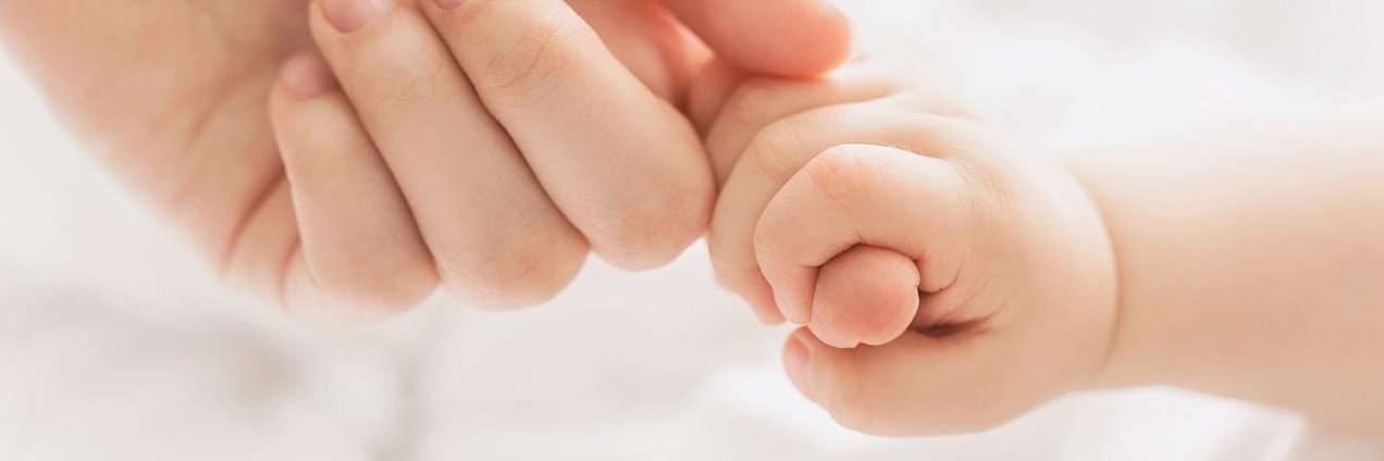 Bereitschaftspflege Finger eines Erwachsenen wird von einer Babyhand umschlossen
