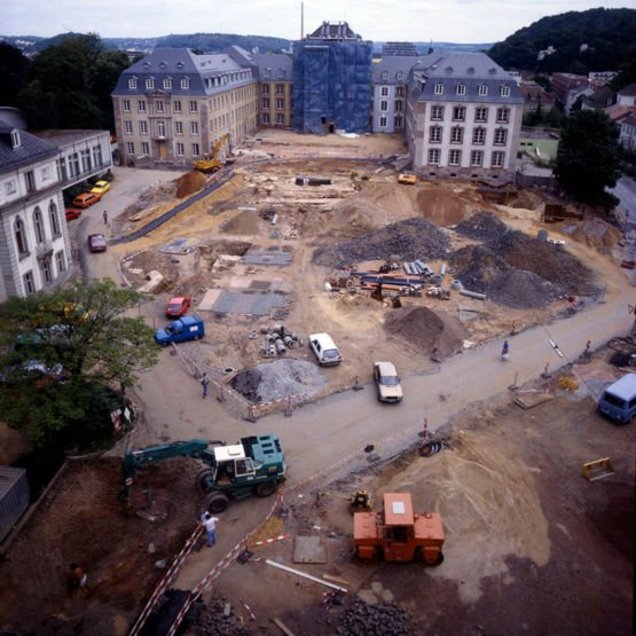 Baustellenfahrzeuge auf aufgebaggertem Vorplatz mit Neubau Mittelbau im Hintergrund