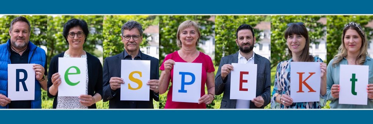 Menschen halten Schilder mit Buchstaben hoch welche das Wort Respekt bilden