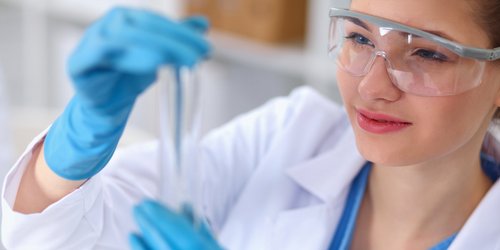 Eine Frau untersucht eine Probe in einem Reagenzglas