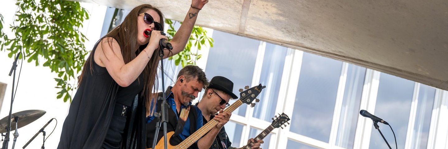 Die Sängerin, der Bassist und der Gitarrist der Band Rozedale auf der Bühne im Schlossgarten.