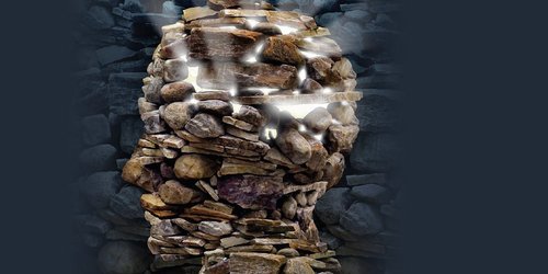 Darstellung eines Kopfes aus Steinen. Durch die Spalten stahlt ein Licht.