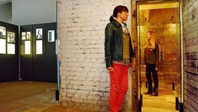 Frau und Kind schauen sich Fotos in einem Museum an 