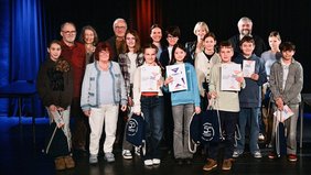 Die Teilnehmenden Jungen und Mädchen des Vorlesewettbewerbs stehen gemeinsam mit der Jury und der Regionalverbandsbeigeordneten Anita Morschette-Sarg auf der Bühne im Schlosskeller.