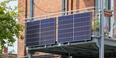 Balkonkraftwerk Ein Balkon an an einem Haus mit zwei PV-Anlangen an der Außenseite