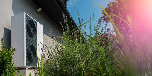 Blick auf eine Wärmepumpe an einer Hauswand