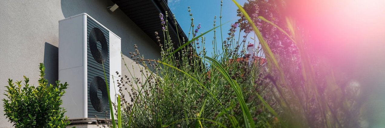 Blick auf eine Wärmepumpe an einer Hauswand