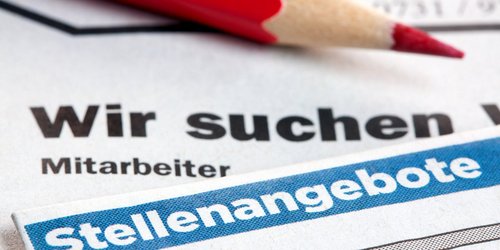 Zeitungsinserate mit Stellenangebote und darauf ein roter Stift