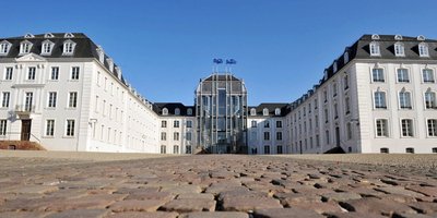Blick aus der Bodenperspektive auf das Saarbrücker Schloss von vorne mit Pflastsersteine des Vorplatzes