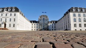 Blick aus der Bodenperspektive auf das Saarbrücker Schloss von vorne mit Pflastsersteine des Vorplatzes