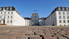 Blick aus der Bodenperspektive auf das Saarbrücker Schloss von vorne mit Pflastsersteine des Vorplatzes