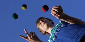 Junge jongliert Junge jongliert mit bunten Bällen