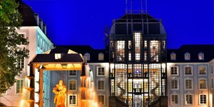 Schloss Saarbrücken mit beleuchtetem Brunnen in Abenddämmerung