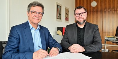 Regionalverbandsdirektor Peter Gillo (l.) und Sven Schäfer, Geschäftsführer der Drogenhilfe Saarbrücken, unterzeichnen gemeinsam die Vereinbarung