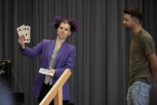 Zauberkünstlerin LilaLucy bei einem Kartentrick mit einem Mann aus dem Publikum auf der Bühne