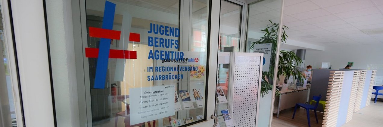 Offen stehende Glastür der Jugendberufsagentur mit Blick in ein Büro