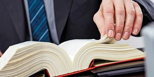Ein Mann blättert in einem Gesetzbuch