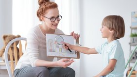 Kind und Frau im Gespräch (Therapie, Adoption, Untersuchung) Frau spricht mit Kind, Kind untersucht Bild mit Lupe