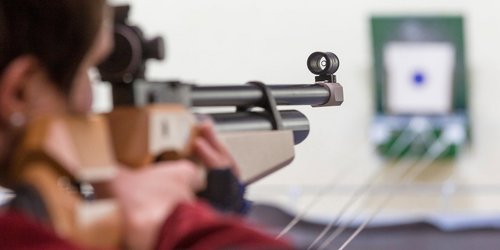 Schützin mit Luftgewehr am Schießstand