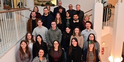 Absolventen 2026 Gruppenbild der 16 Azubis, der Regionalverbandsdirektorin und weiterer Mitarbeitende der Regionalverbandsverwaltung auf einer Treppe im Saarbrücker Schloss