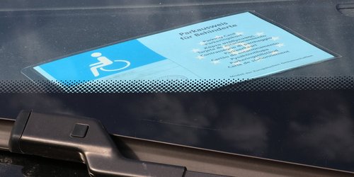 Parkausweis für Behinderte hinter der Windschutzscheibe