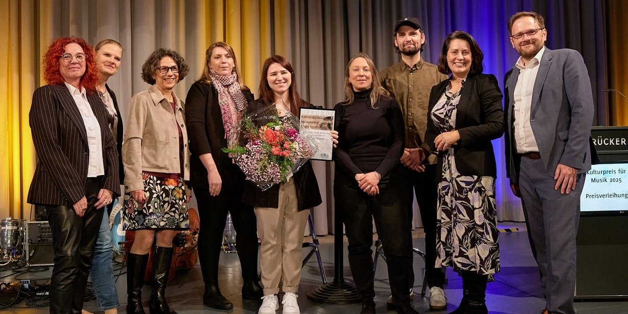 Die Preisträgerin mit der Jury des Kulturpreises für Musik 2025 und Regionalverbandsdirektorin Dr. Carolin Lehberger (2. v. r.). Foto: Kerstin Krämer Die Jurymitglieder des Kulturpreises für Musik 2025 posieren mit der Preisträgerin Isabell Krohn und Regionalverbandsdirektorin Dr. Carolin Lehberger auf der Bühne des Festsaals für ein Foto. Isabell Krohn hält ihre Urkunde und einen Blumenstrauß.