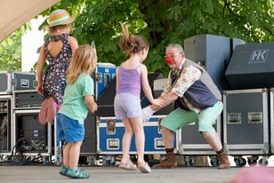 Willi beim Kindertheater auf der Schlossböhne. Er animiert der junge Mädchen, die vor ihm hüpfen.
