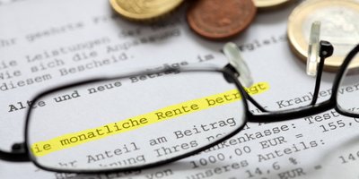 Brille und Geldmünzen auf Grundsicherungsbescheid 