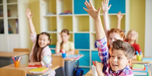 Grundschüler melden sich im Unterricht