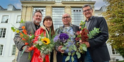 Die Frauenbeauftragte Mirjam Altmeier-Koletzki sowie Regionalverbandsdirektor Peter Gillo, die Vertrauensperson der Schwerbehinderten Menschen, Volker Kelleter und Personalratsvorsitzender Johannes May halten bunte Blumensträuße in die Kamera