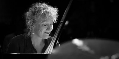 Eine schwarz-weiß Aufnahme der Jazzmusikerin Julia Hülsmann am Piano