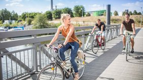 Junge Menschen fahren auf dem Fahrrad durch den Osthafen von Saarbrücken