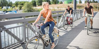 Junge Menschen fahren auf dem Fahrrad durch den Osthafen von Saarbrücken