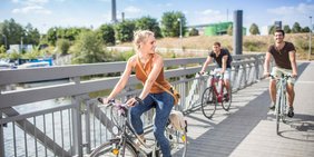 Junge Menschen fahren auf dem Fahrrad durch den Osthafen von Saarbrücken