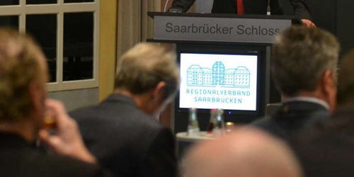 Männer im Konferenzraum sitzend mit Blick auf Bildschirm