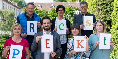 Eine Gruppe Menschen hält Schilder mit einzelnen Buchstaben hoch welche das Wort respekt formen