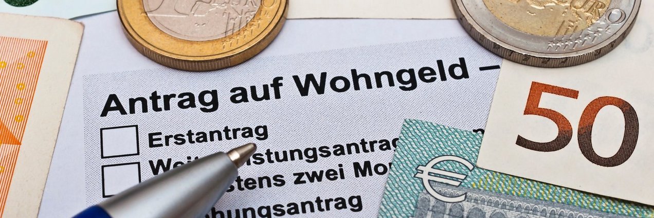 Wohngeldantrag mit Geld und einem Kugelschreiber